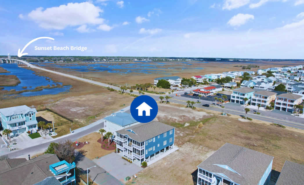 Aerial view of a coastal neighborhood with Sol Mar condo building marked by a blue icon, a bridge labeled Sunset Beach Bridge, a marshland, and the ocean in the background on a sunny day.