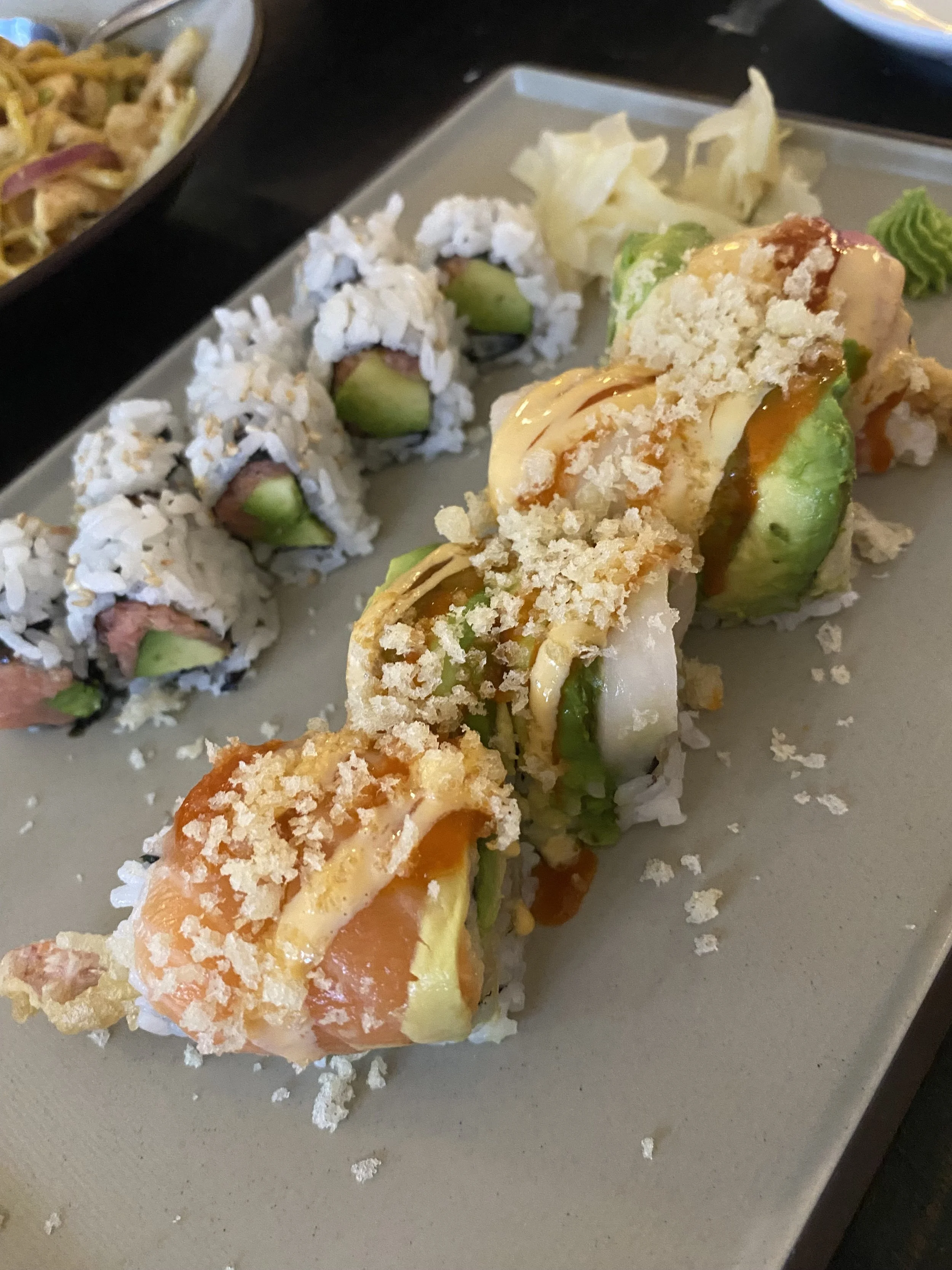 Sushi rolls with avocado, crab, and sesame seeds, served with wasabi and pickled ginger from Calabash Gourmet