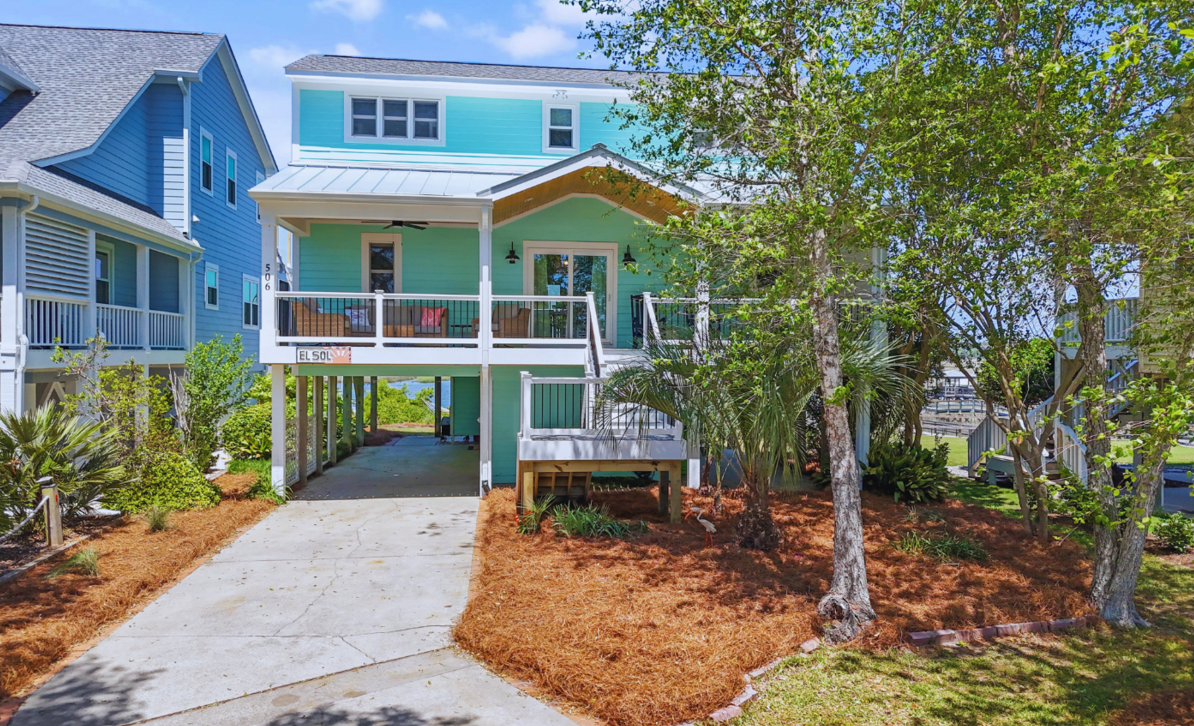 Exterior of El Sol, a colorful elevated beach house with a front porch in Sunset Beach, NC.
