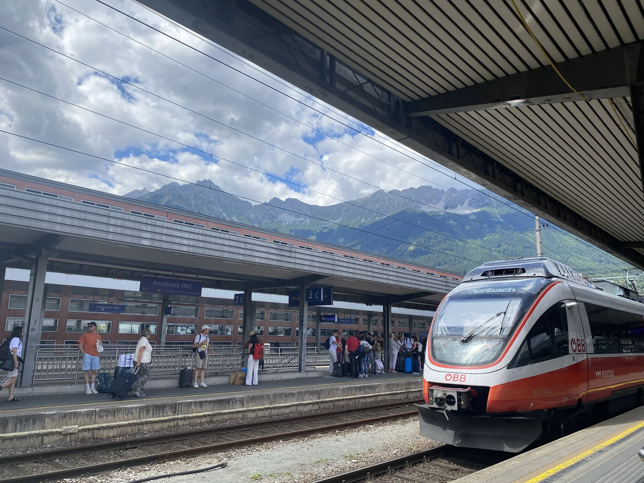 Train platform with a modern train and mountains in the background, in Innsbruck, Austria