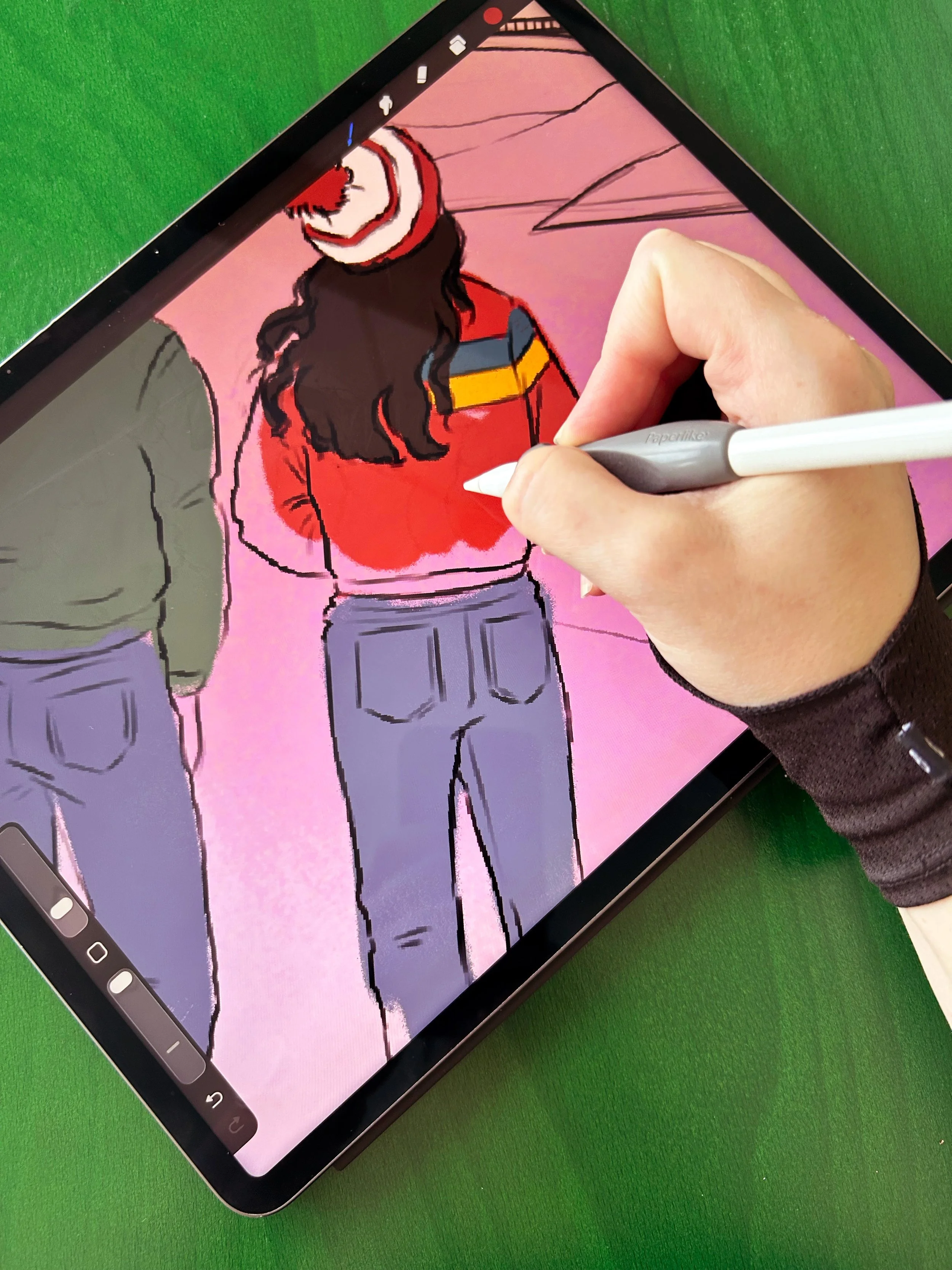 En hand som håller en stylus som ritar på en surfplatta med en digital teckning av ett kvinnochile.