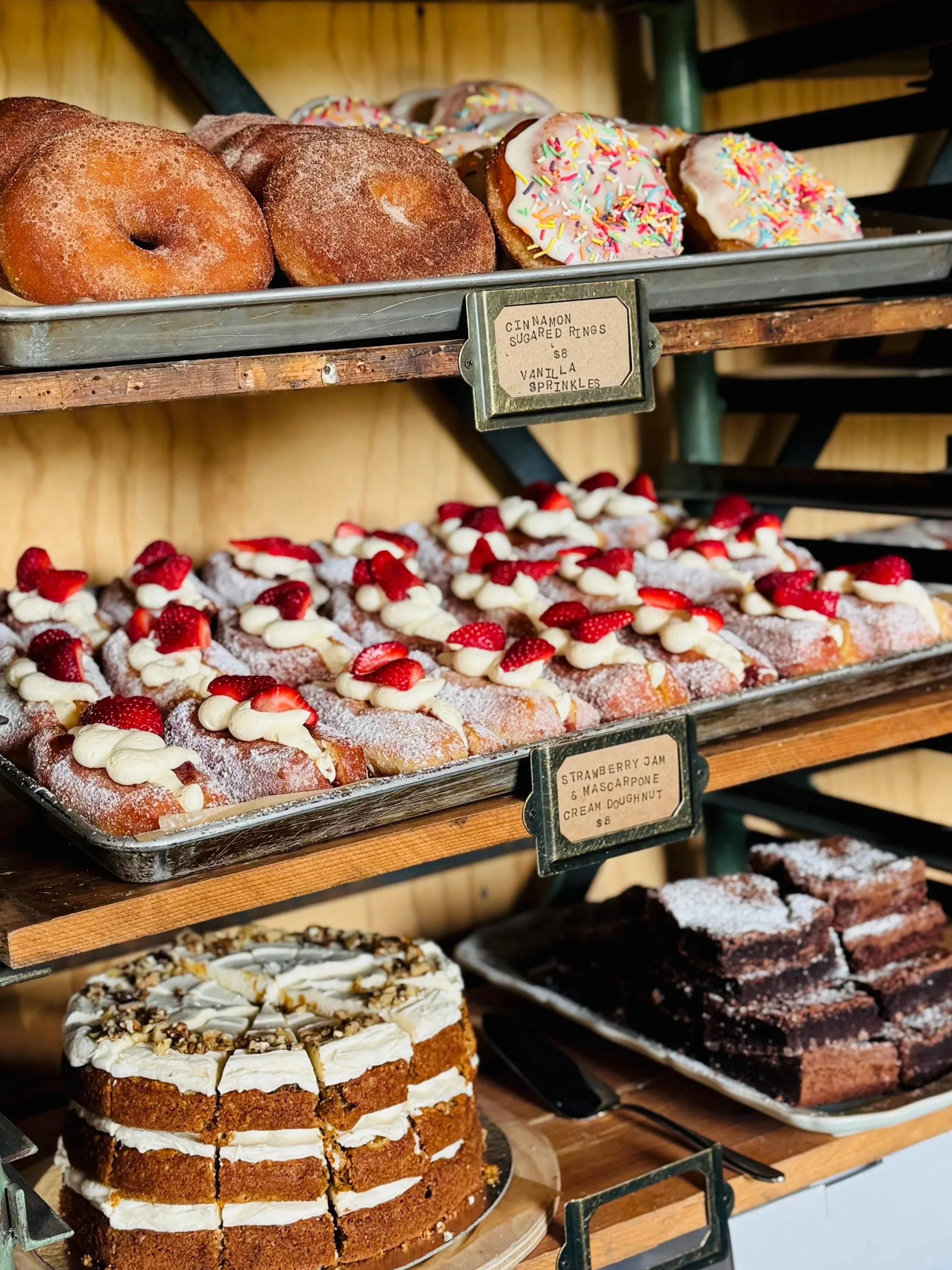 STABLE baked goods including cinnamon sugar donut rings, cinnamon scrolls, filled donuts with strawberry jam and cream, brownies and cake in the bakery.
