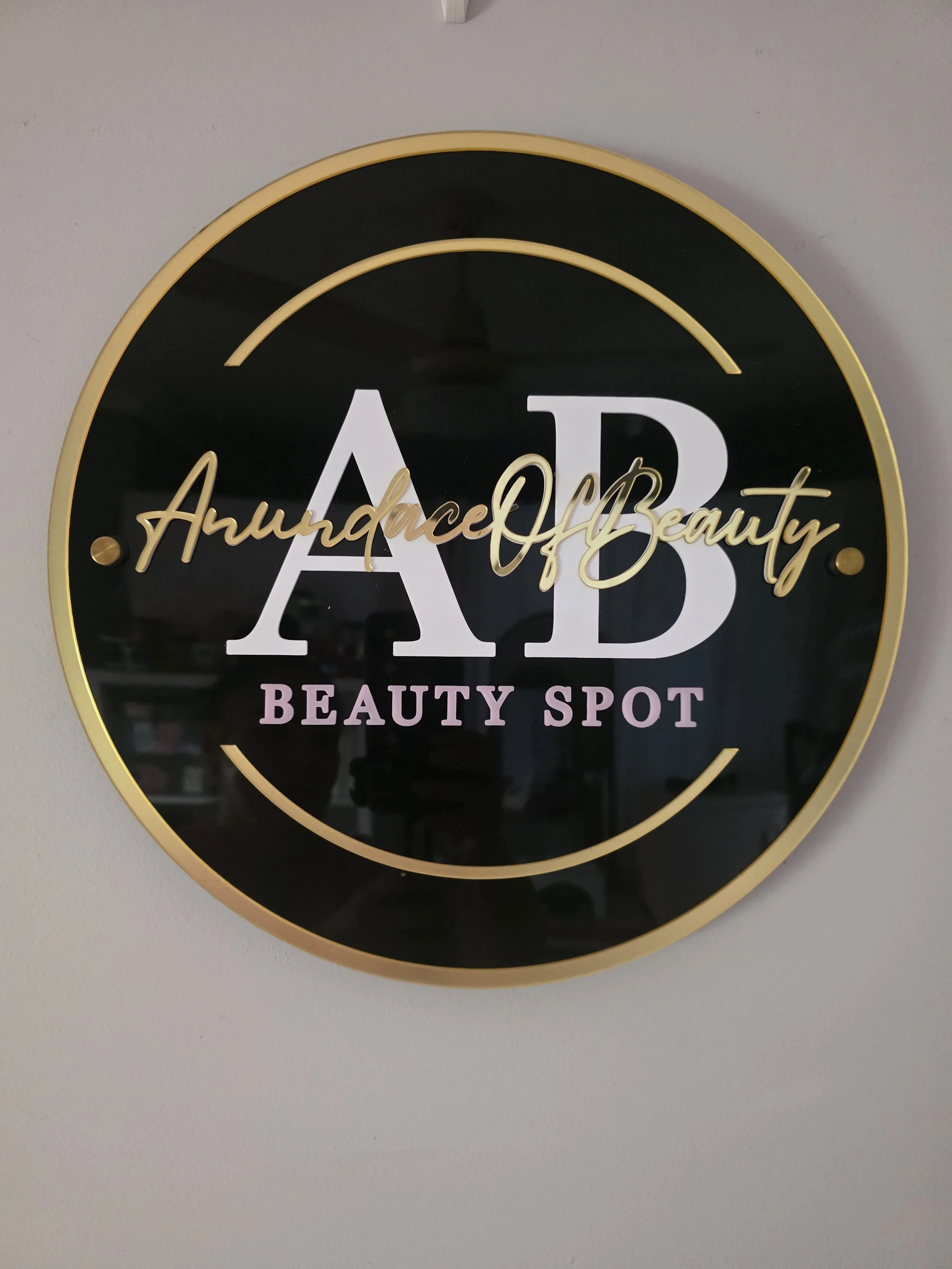 Round black clock with gold accents, displaying the words 'Audiance & Beauty' and 'BEAUTY SPOT' on the face.