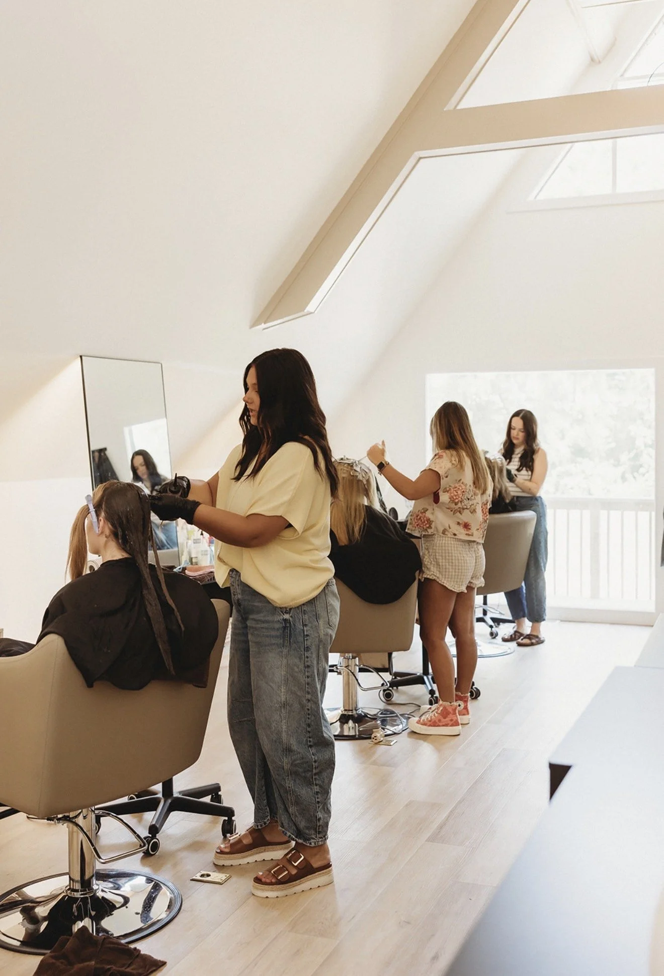 Hair stylists working with clients in a bright, modern salon