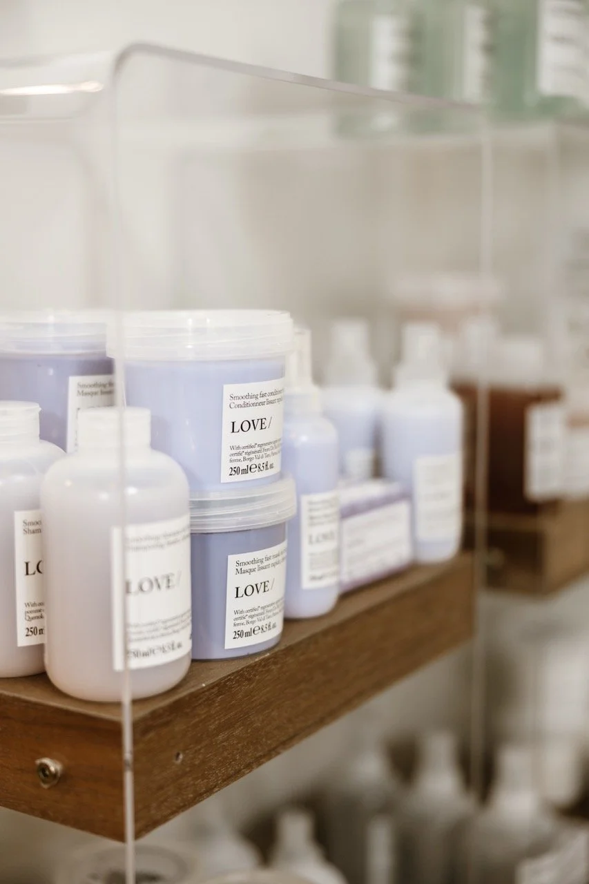 Shelf displaying LOVE skincare and haircare products in bottles and tubs