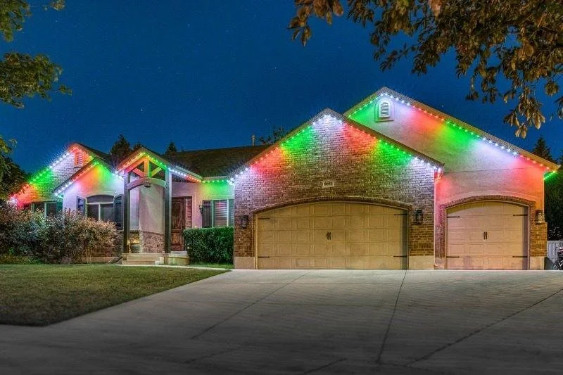 A house decorated with colorful Christmas string lights at night.