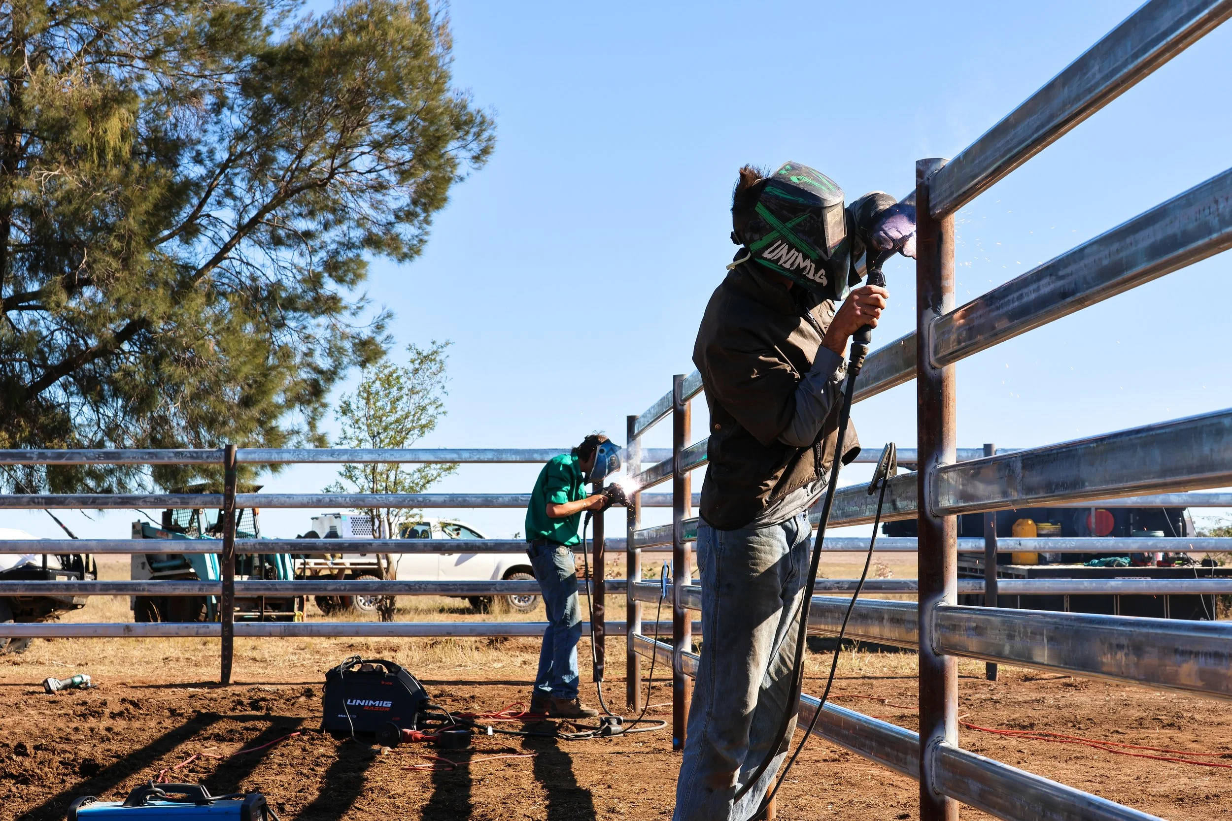 G8K Rural Co team welding a metal fence outdoors