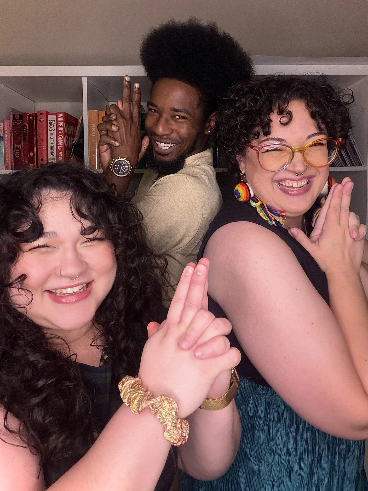 Three people smiling and laughing, holding up finger guns and posing like Charlie's Angels (movie)