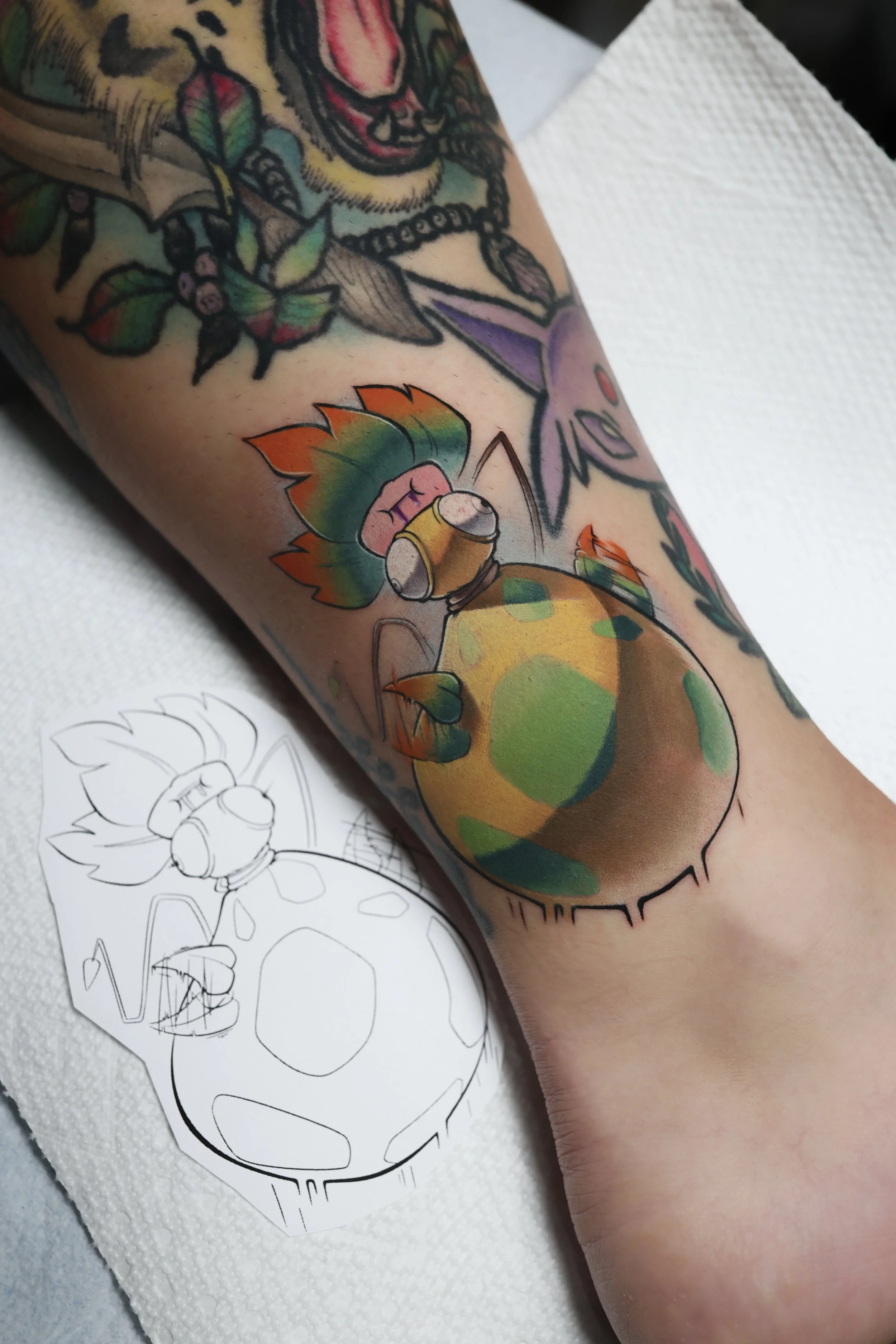 Colorful tattoo of a derpy version of the Pokemon Mega Victreebel bouncing.