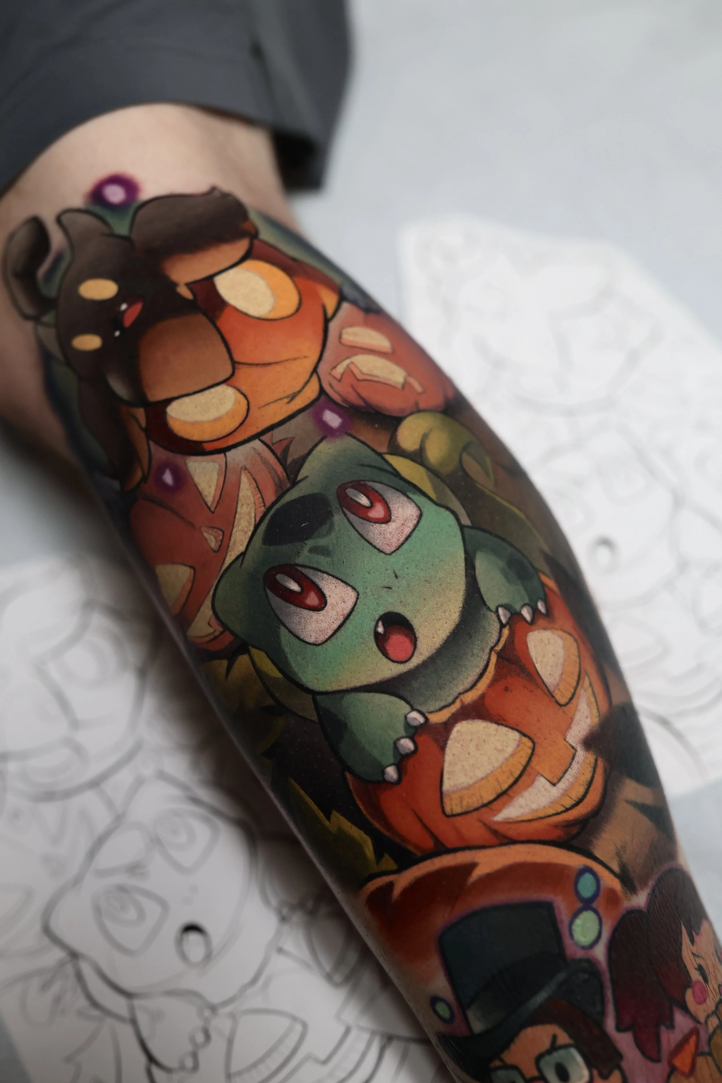 colorful tattoo of pokemon featuring Pumpkaboo and bulbasaur in the middle of a spooky pumpkin patch.