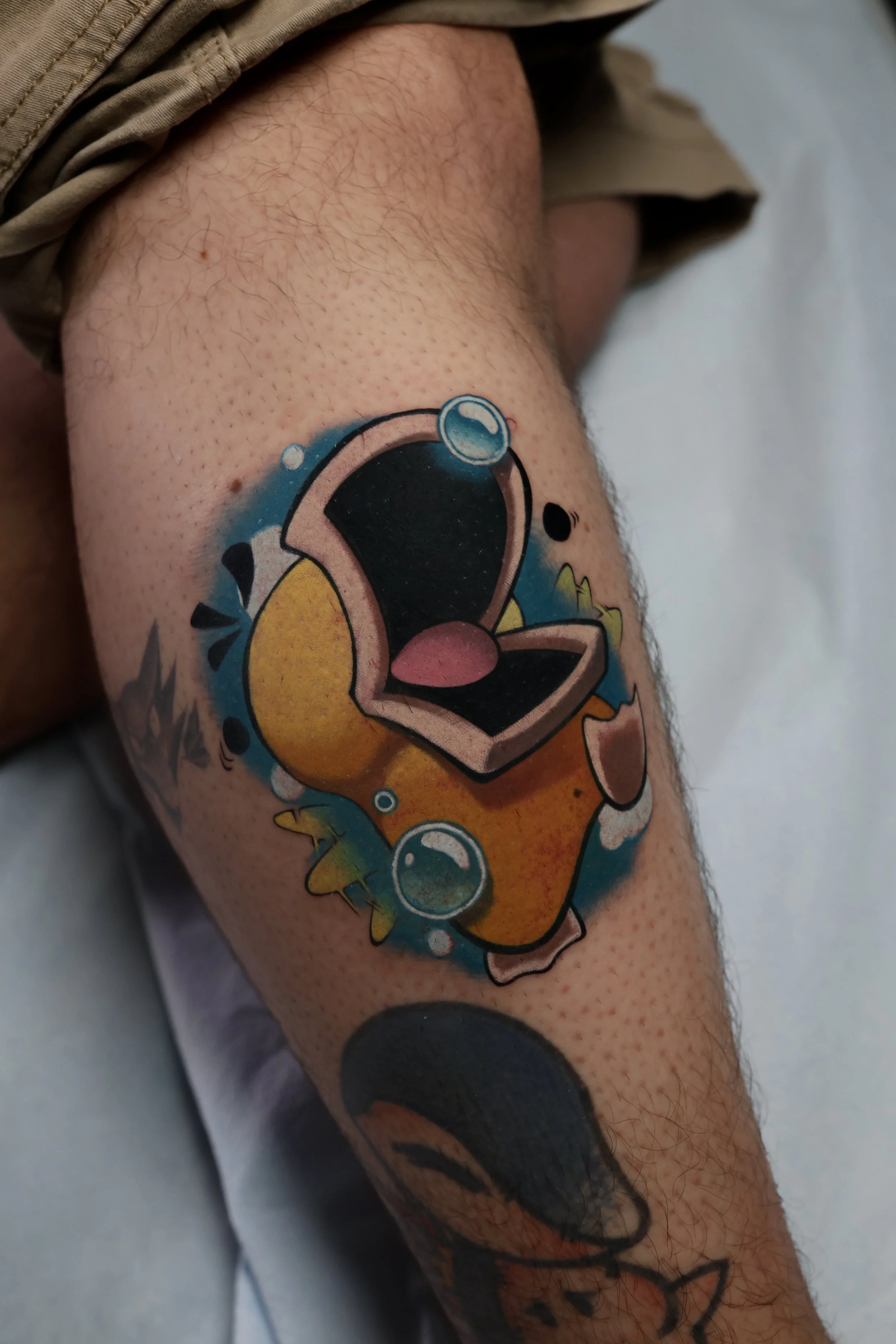 Colorful and derpy tattoo of the pokemon Psyduck freaking out