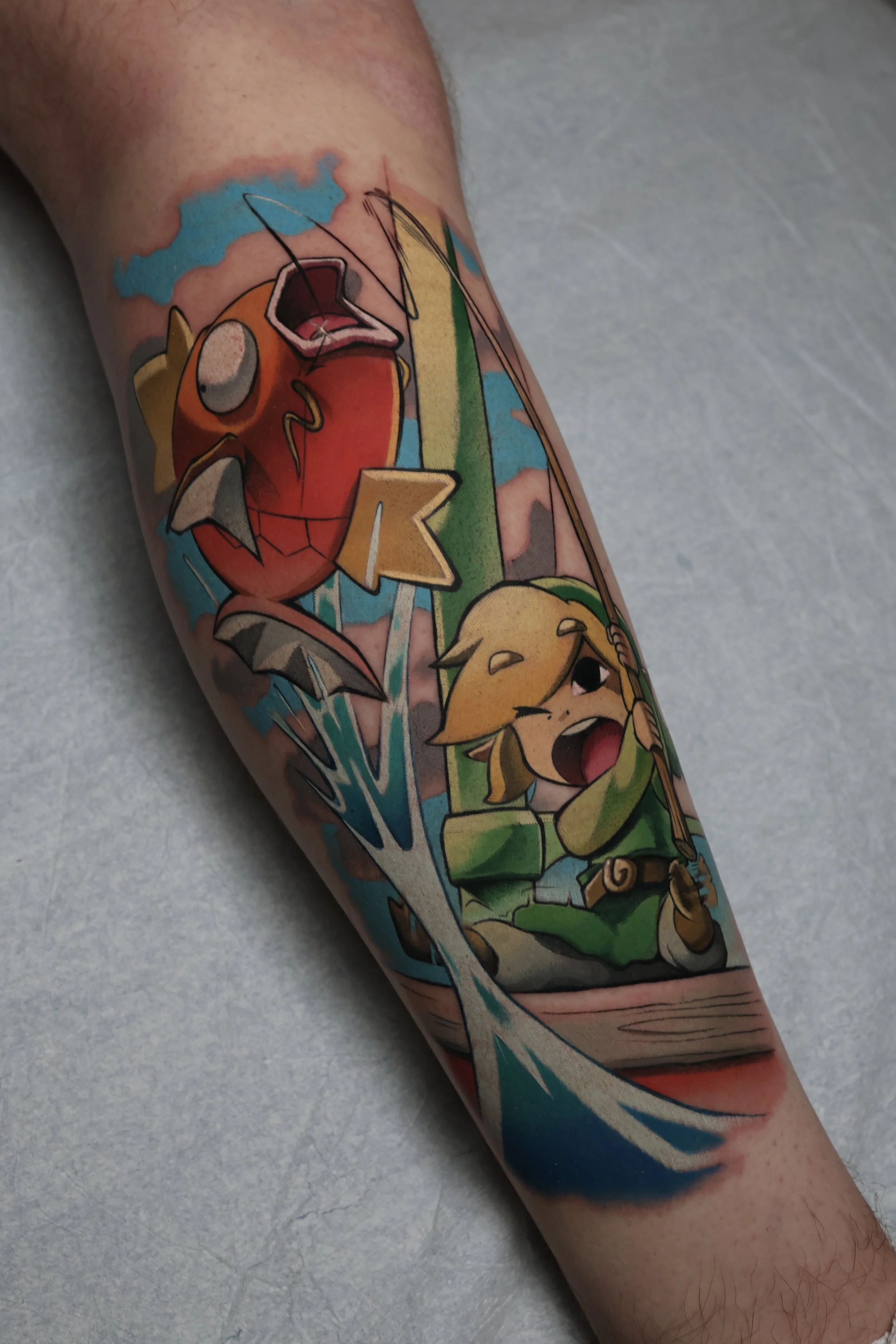 Colorful tattoo of kid Link from the Legend of Zelda series fishing and pulling the Pokemon Magikarp out of the water 