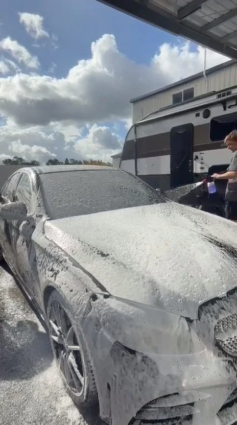 Snow foam going on a black Mercedes during an exterior wash.