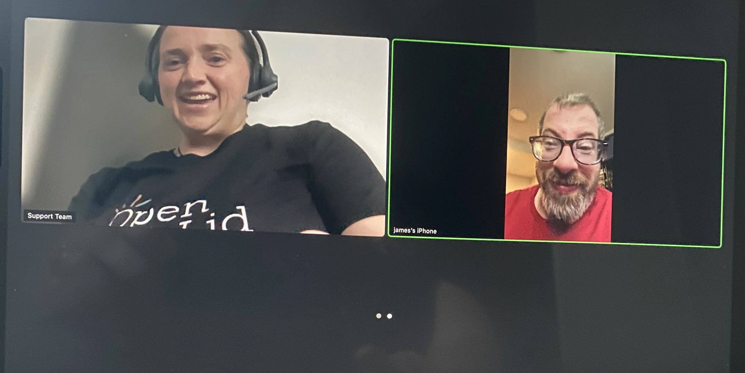 A screenshot of a video call showing two men smiling and talking, one with headphones and a microphone, labeled as 'Support Team,' and the other with glasses and a beard, his name is James, seen on his iPhone.