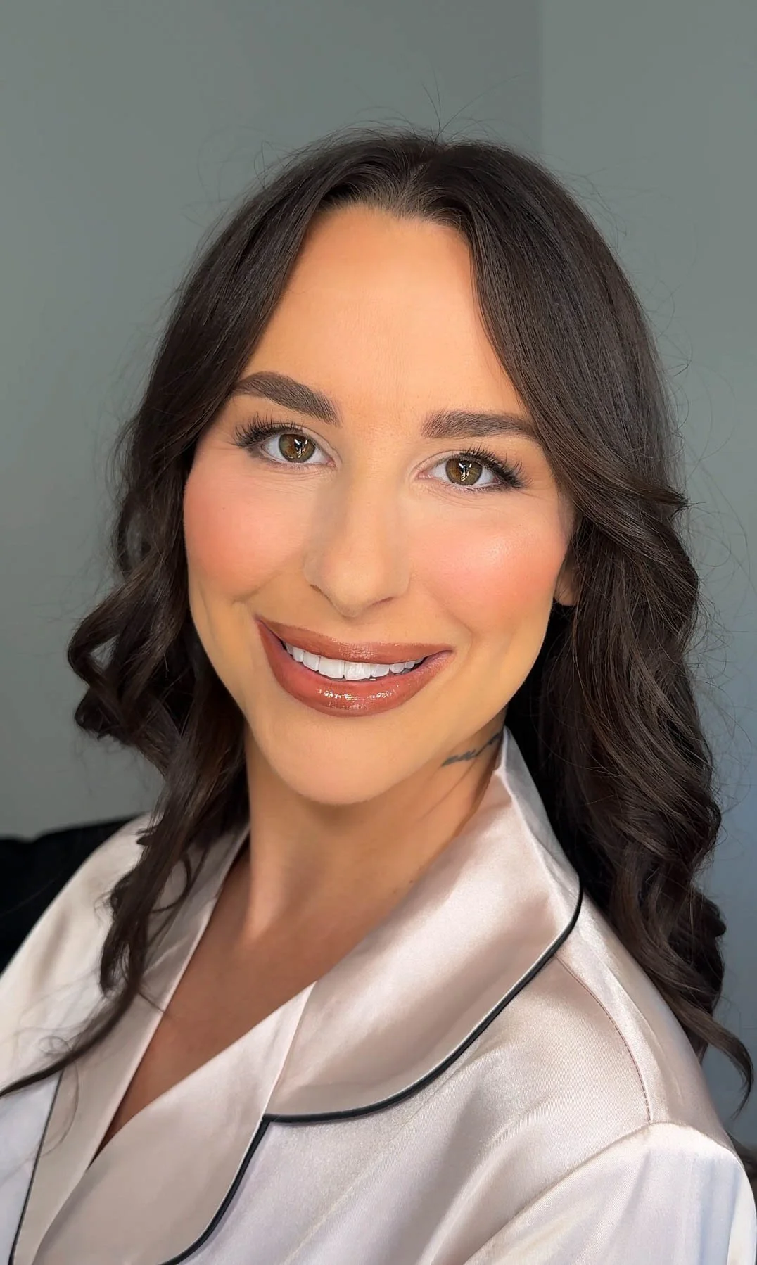 Soft glam makeup on a brunette with radiant skin, defined eyes and a glossy nude lip.