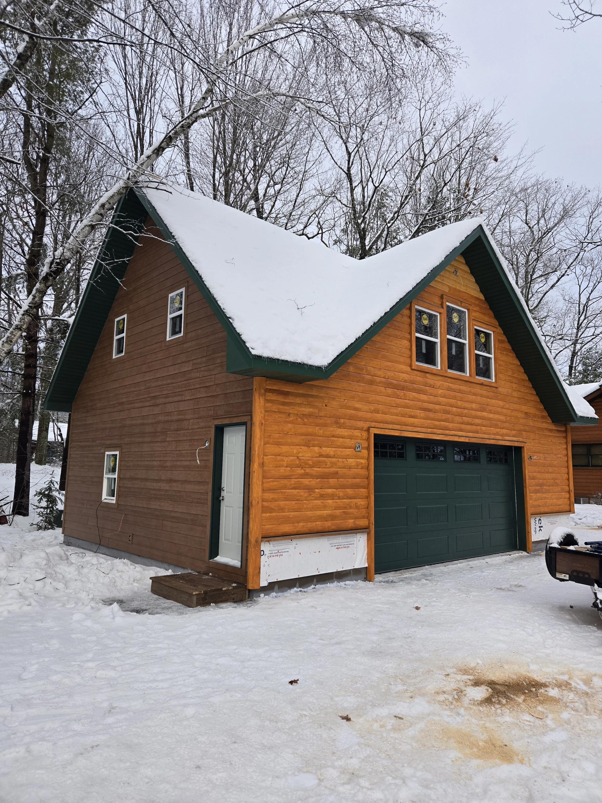 Log cabin siding with green garage door