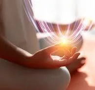 Person holding a glowing orb of light in their hand.