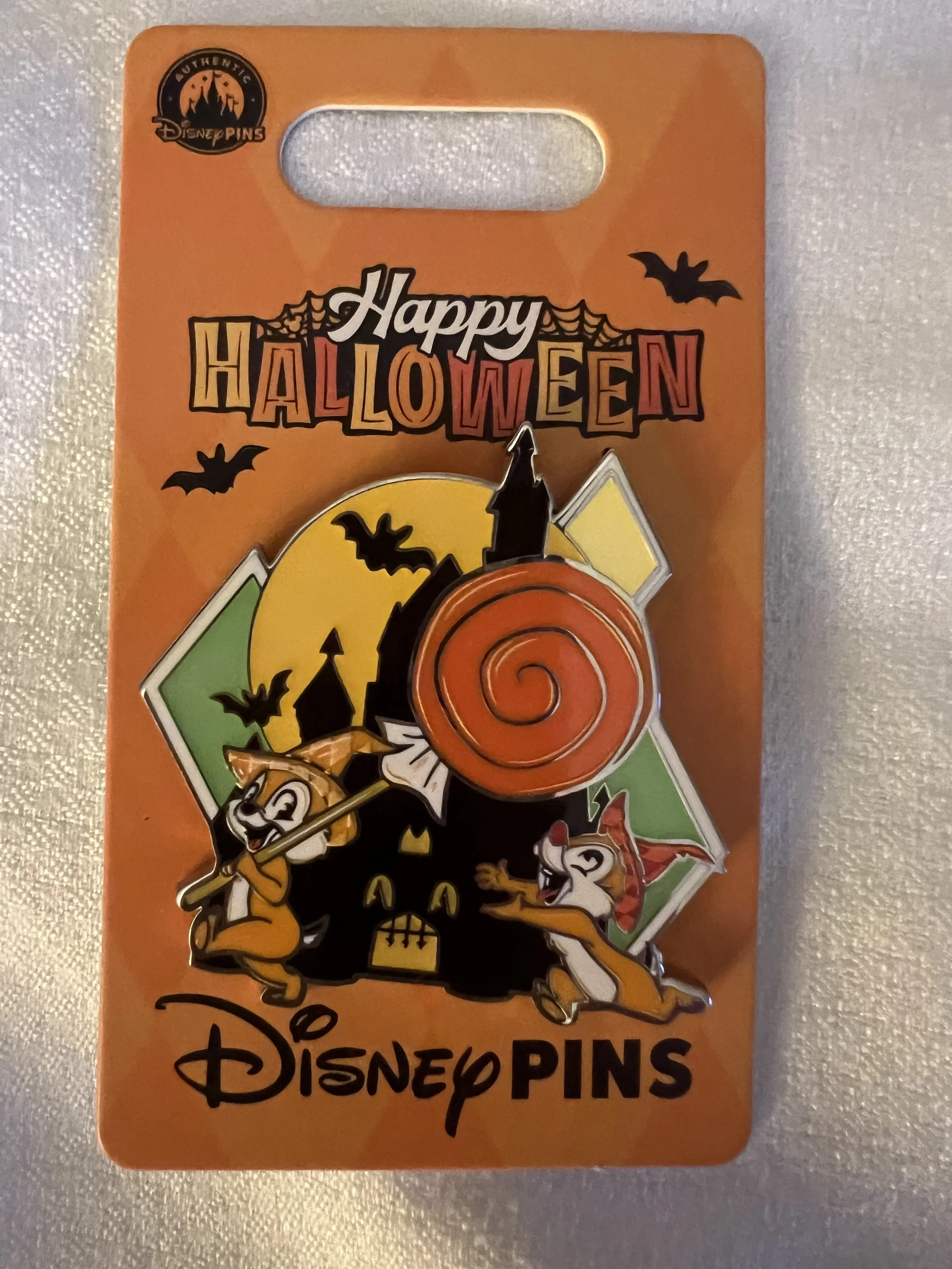 Orange Disney Pins card featuring Mickey Mouse and a spooky Halloween theme, with bats and pumpkins.
