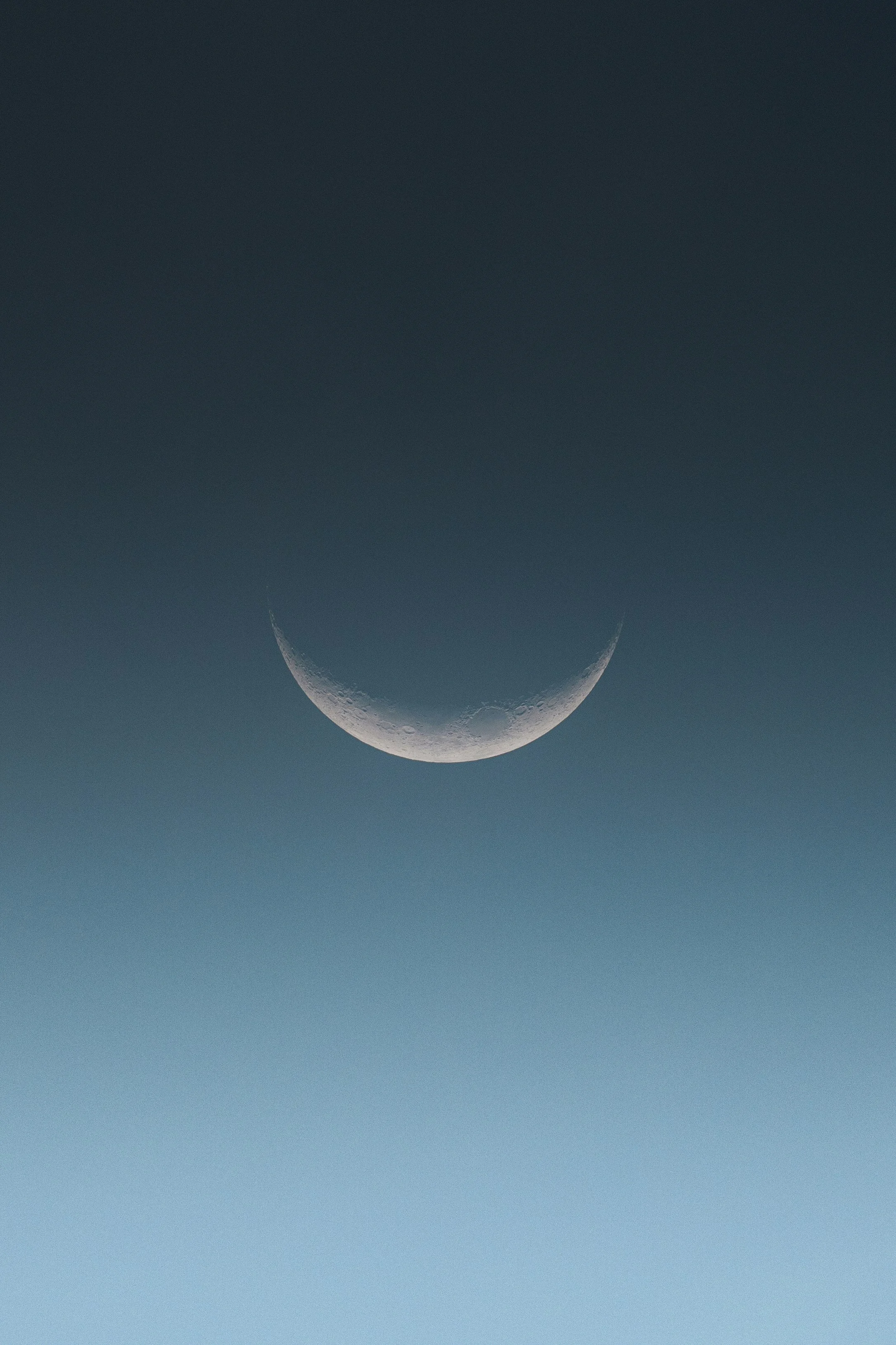 A crescent moon against a dark sky.