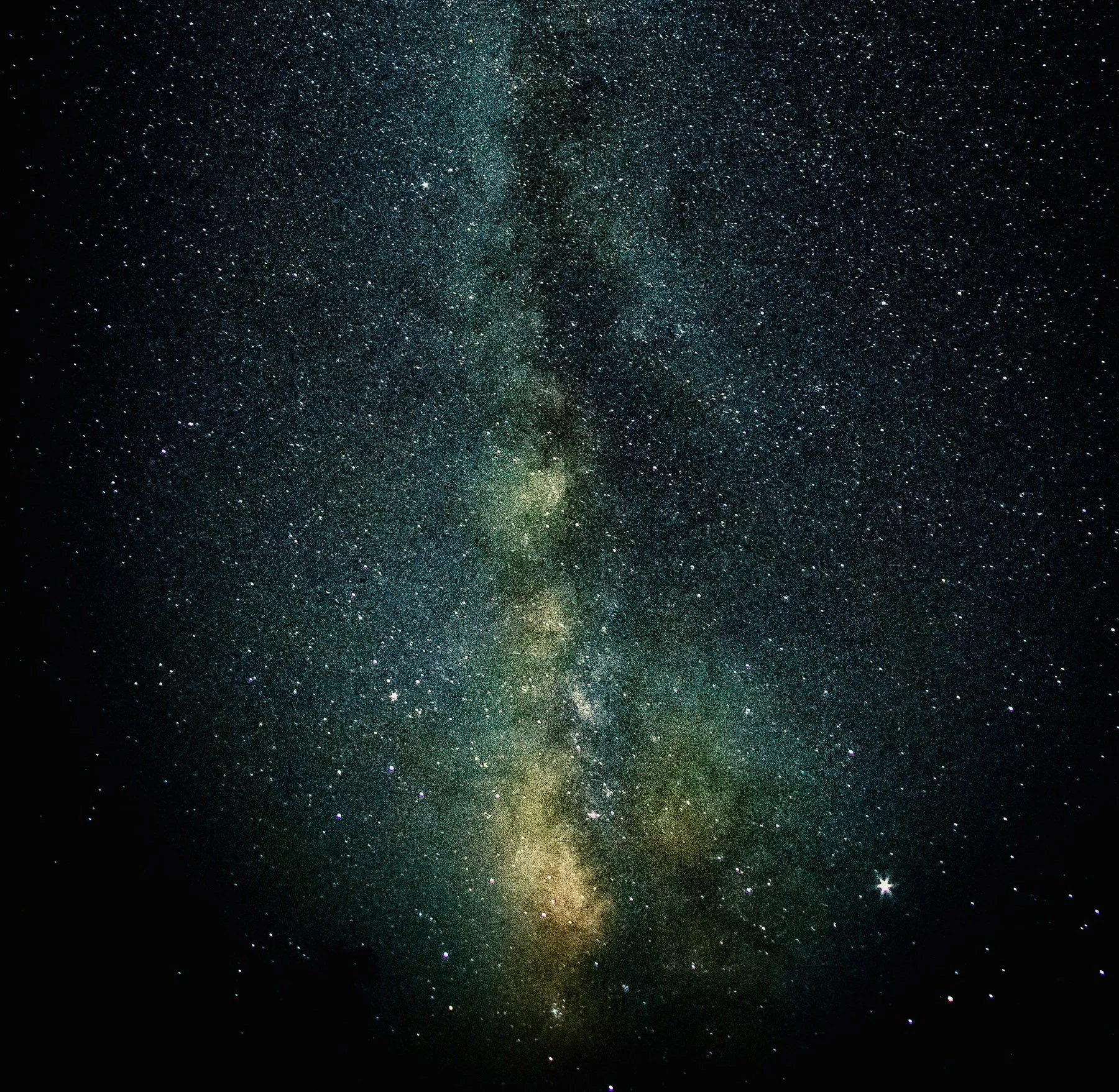 A star-filled night sky with the Milky Way galaxy visible as a bright, dense band of stars running vertically through the center.