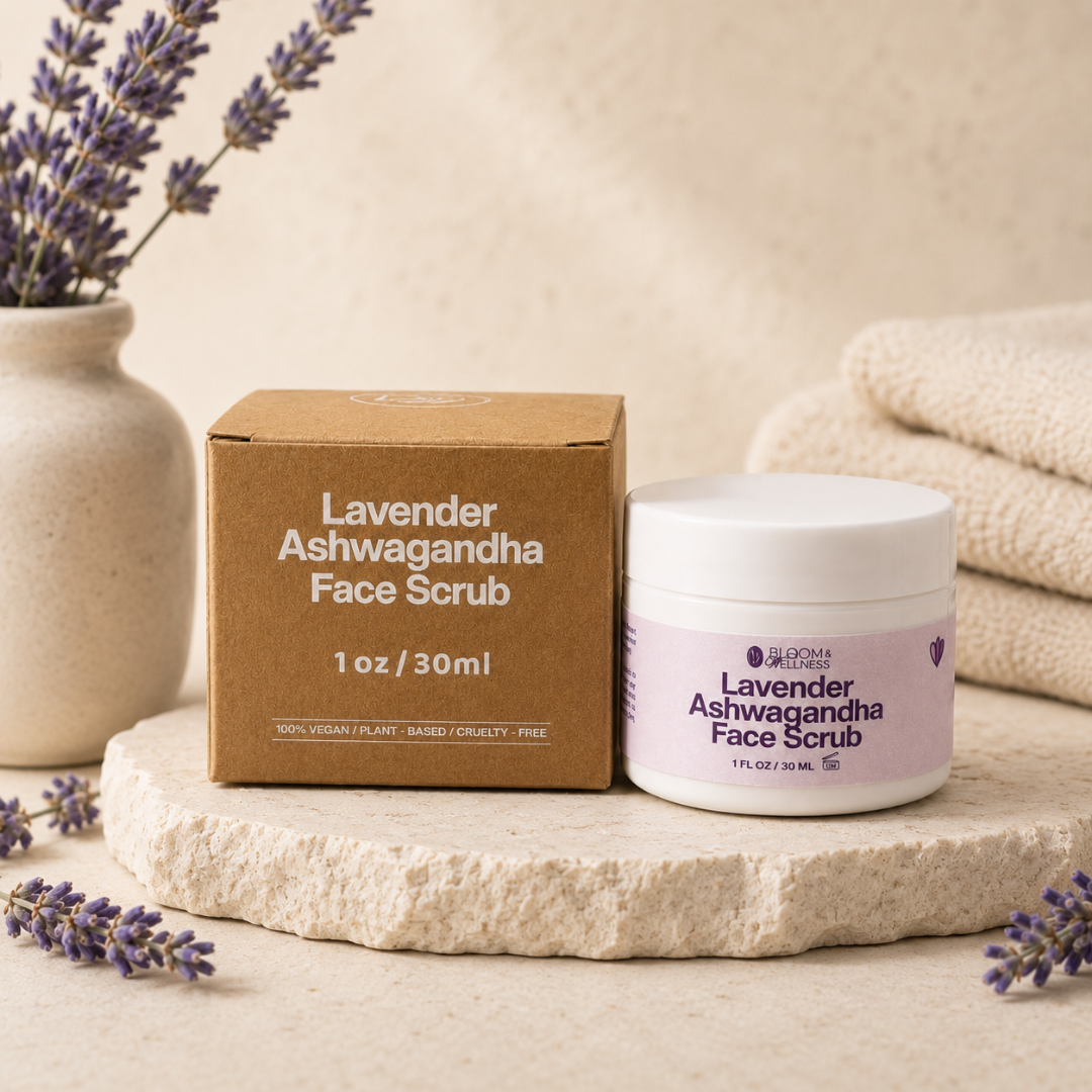 A jar of lavender Ashwagandha face scrub and its packaging box on a beige stone surface, with lavender flowers and folded towels in the background.