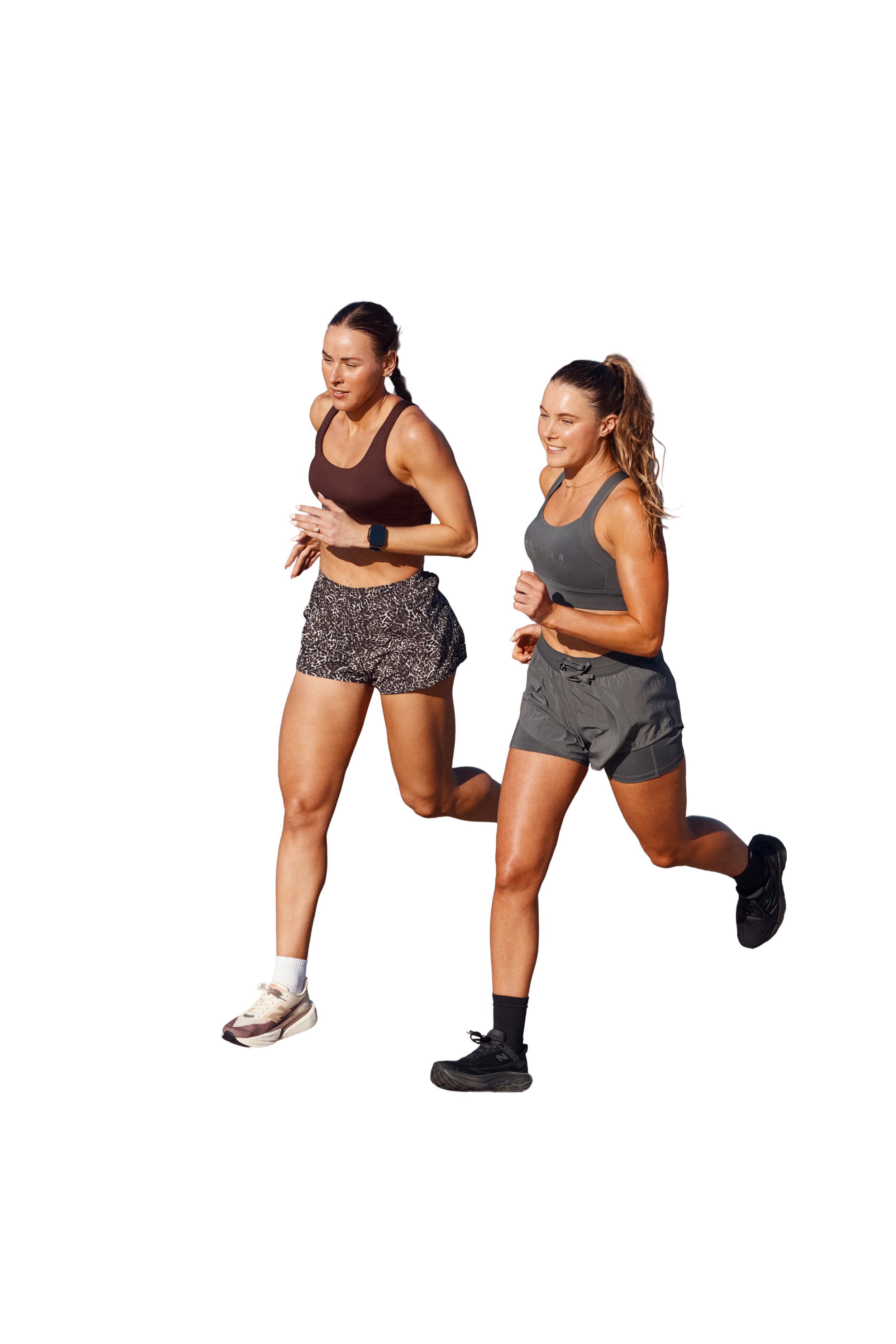 Two women running outdoors, both wearing athletic clothing and sneakers.