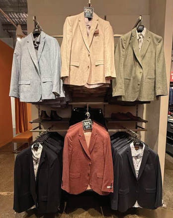 Display of women's blazers and men's blazers on hangers with a 30% off sign.