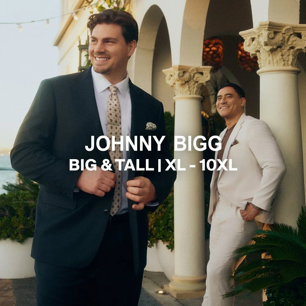 Two men in suits at an outdoor venue with arches and columns. One man is in a dark suit with a patterned tie, and the other in a white suit. Text overlay says 'JOHNNY BIGG BIG & TALL | XL - 10XL'.