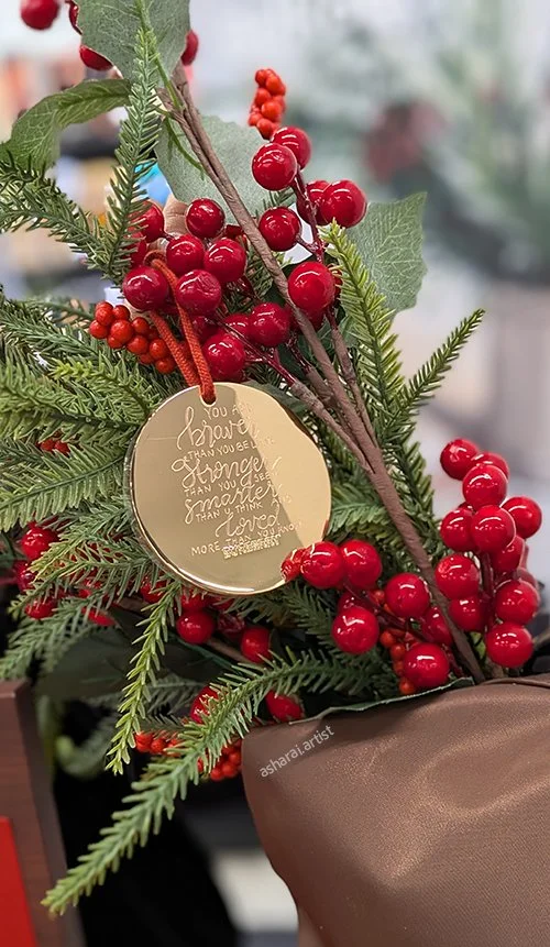 Gold metal Burberry gift with purchase ornament personalized with custom hand engraving at Sephora.

