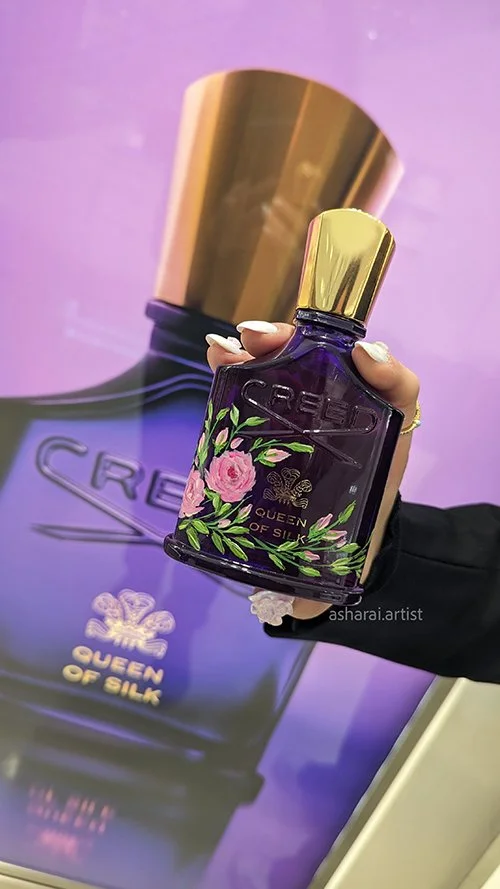 Creed Queen of Silk perfume bottle featuring hand painted pink roses, showcasing luxury event artist bottle painting at Holt Renfrew