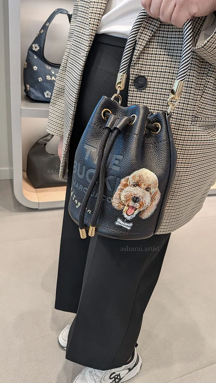 Marc Jacobs black leather bag featuring custom hand-painted artwork by AshaRai, luxury event artist, during a live in-store painting event at the Marc Jacobs boutique in Yorkdale, Toronto.