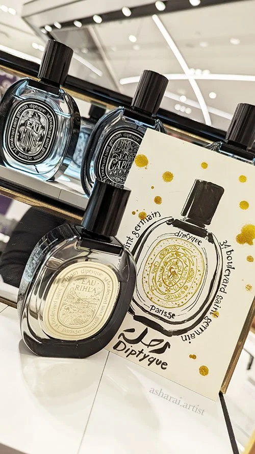 Diptyque Eau Rihla perfume bottle illustrated in watercolor by AshaRai, live event artist, at Holt Renfrew Yorkdale.
