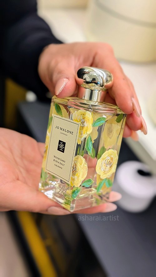 o Malone London Wood Sage & Sea Salt bottle featuring hand-painted yellow roses, showcasing live bottle painting at the Sherway Gardens boutique.