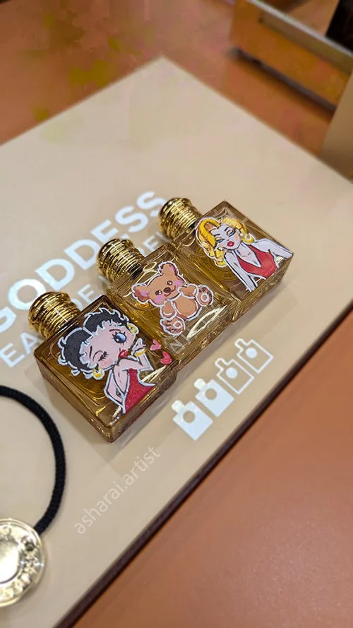 Three small perfume bottles with cartoon character hand painted