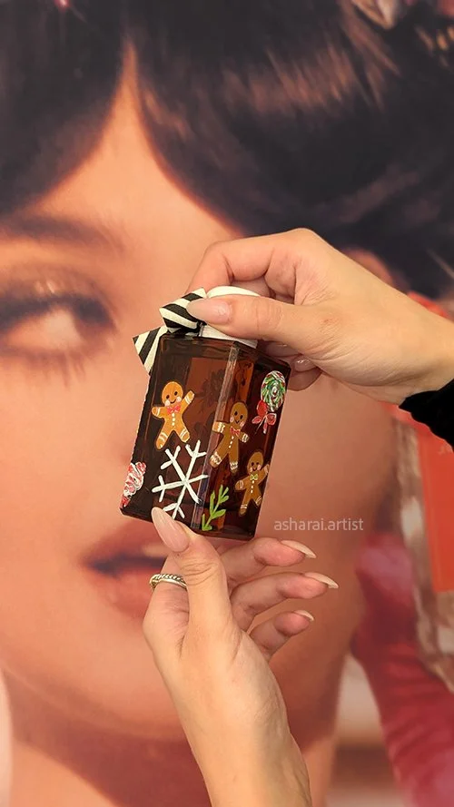 Jo Malone Ginger Biscuit Cologne bottle featuring hand-painted ginger biscuits and snowflakes, showcasing festive live bottle painting for a Christmas event.
