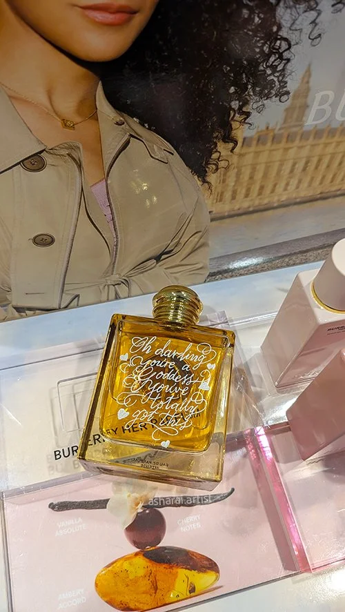 Live hand engraving of Burberry Goddess Parfum at the Shoppers Drug Mart launch event at Square One, Mississauga, featuring a personalized message.