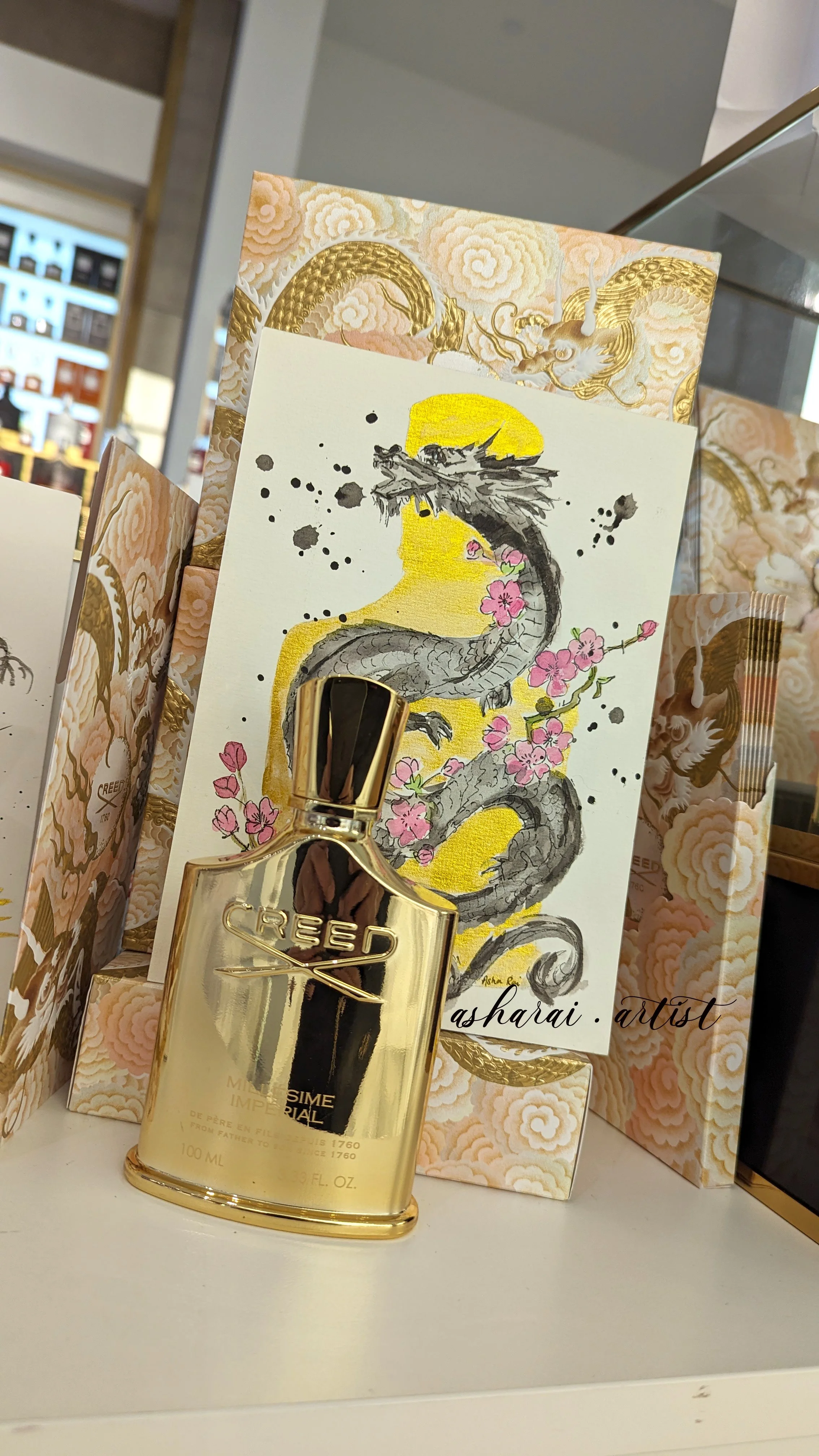 Creed Millésime perfume bottle featuring a watercolor dragon illustration created live by AshaRai, luxury event artist, for the Year of the Dragon at Holt Renfrew Square One in Mississauga.