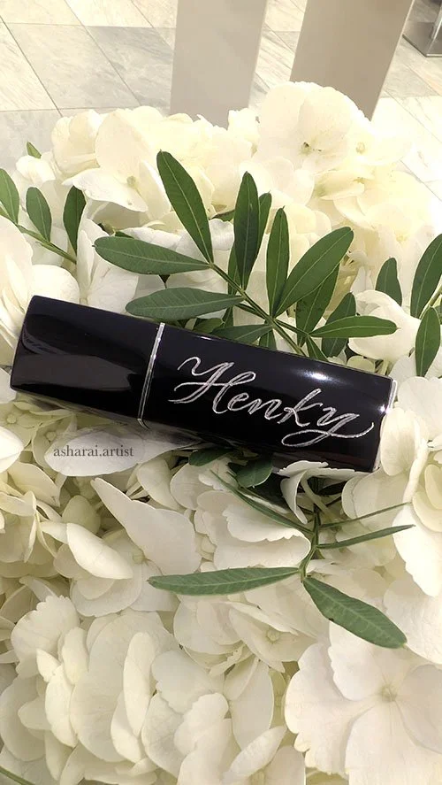 Chanel metal-finish lipstick case personalized with a name through hand engraving.