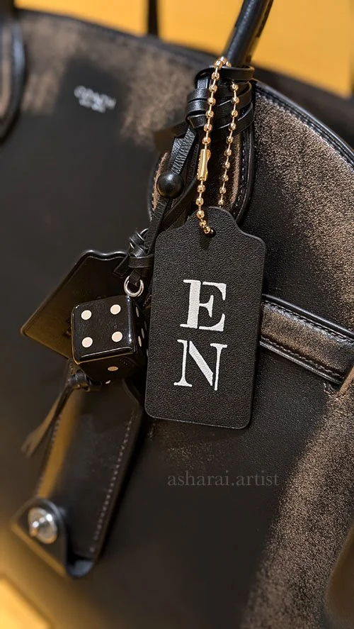 Black Coach handbag featuring custom hand-painted initials “E N,” created live by a leather painter at the Coach event at Holt Renfrew Bloor Street in Toronto.