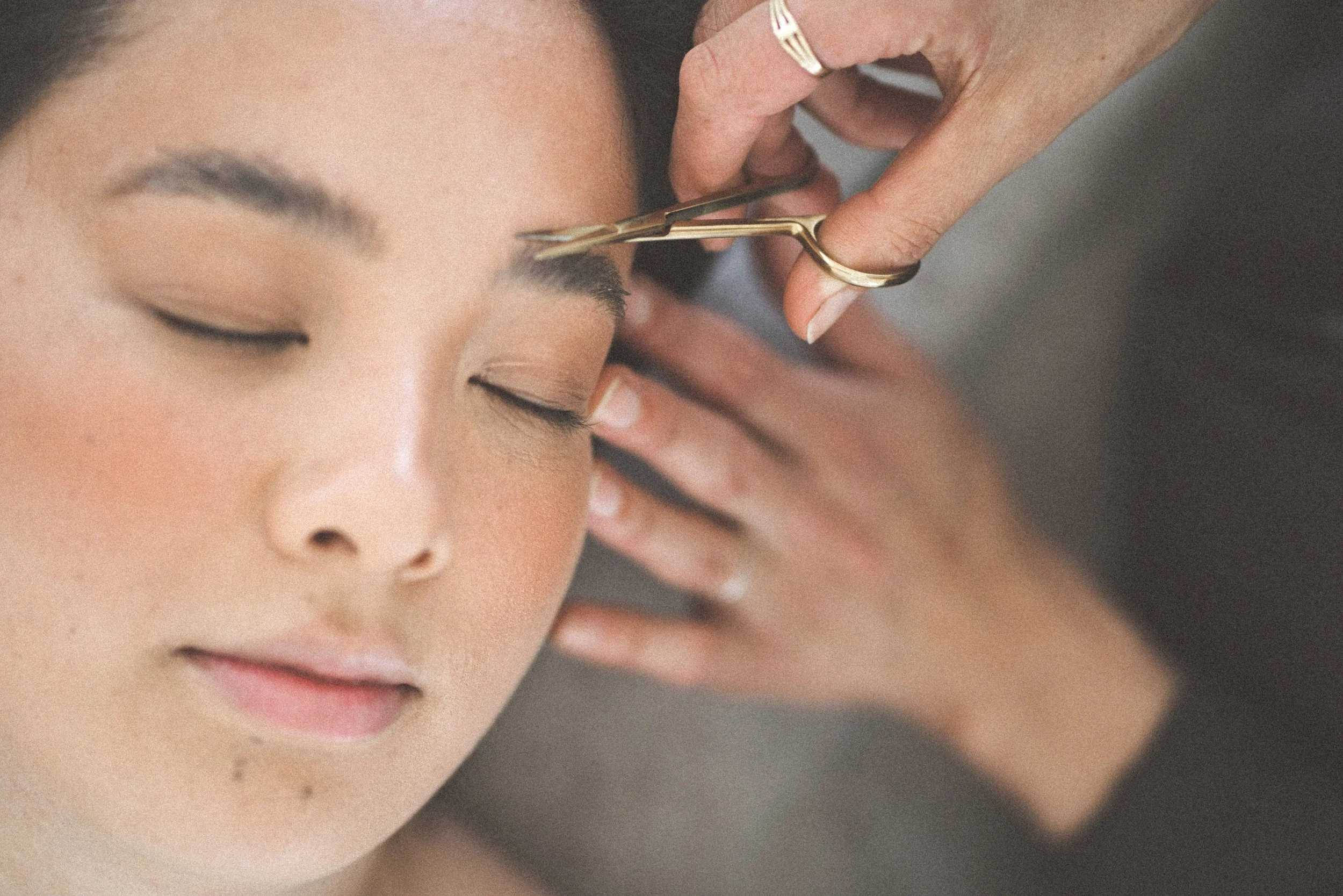 Woman getting eyebrows trimmed and sculpted.