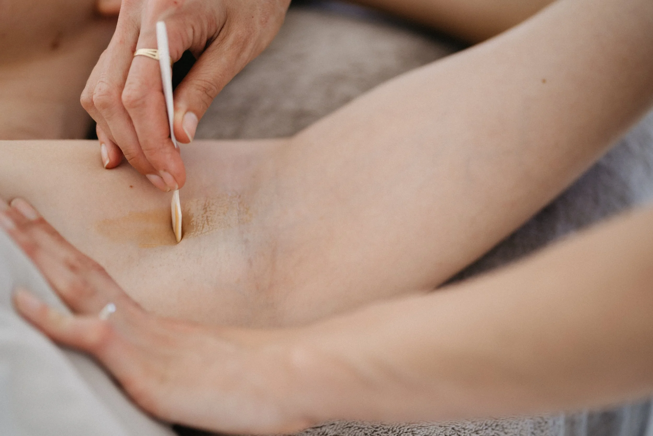 Armpit being waxed with organic sugar wax