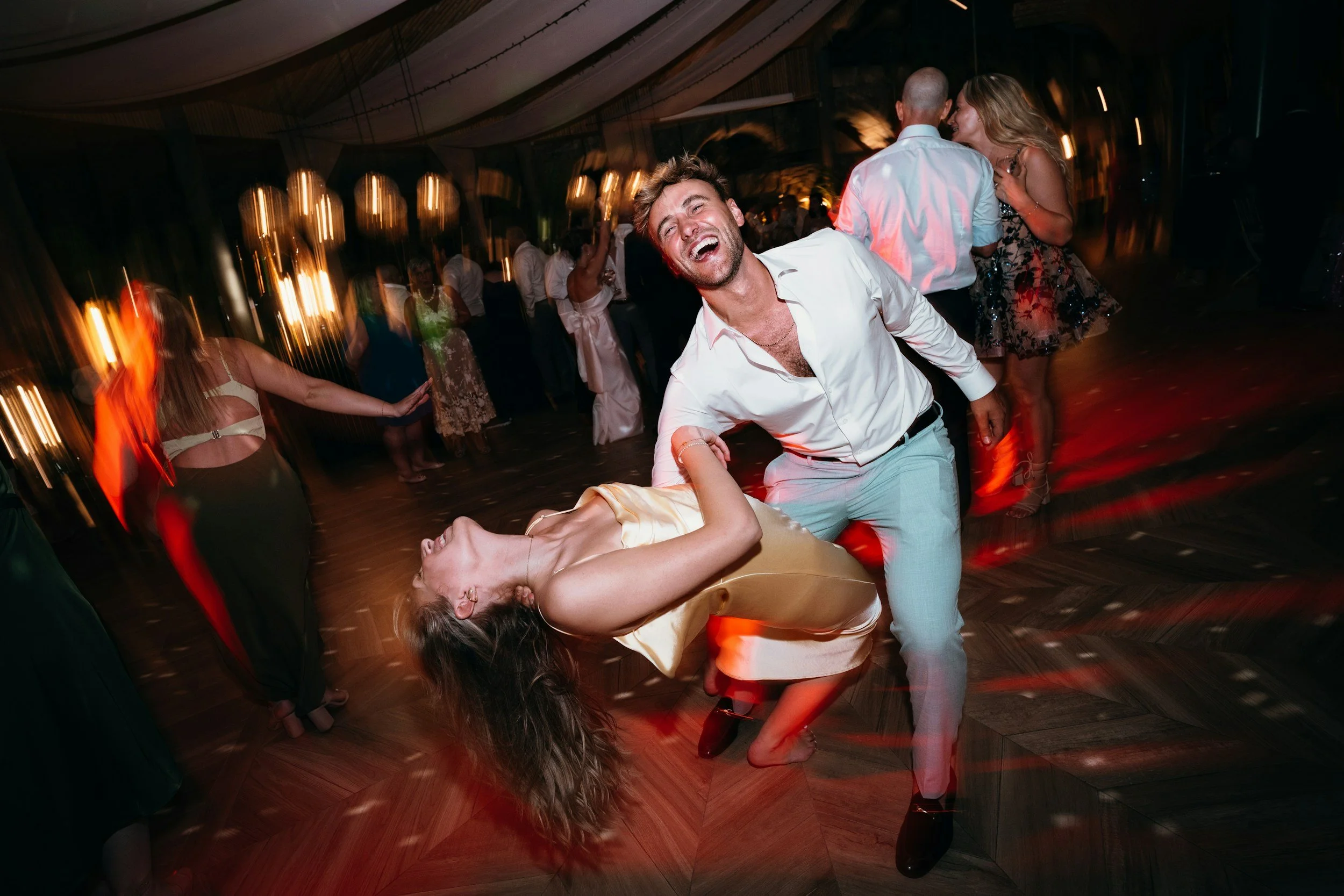People dancing at a party with warm lighting and blurred background.