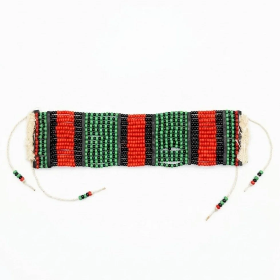 Beaded bracelet with red, black, and green beads, featuring a pixelated pattern.