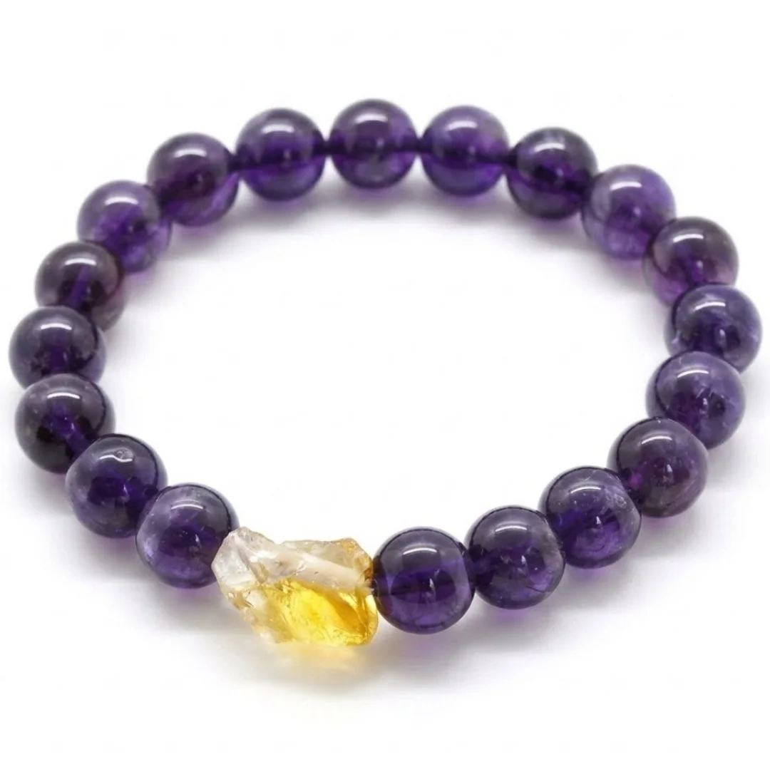 Purple beaded bracelet with a yellow and clear stone accent on white background.