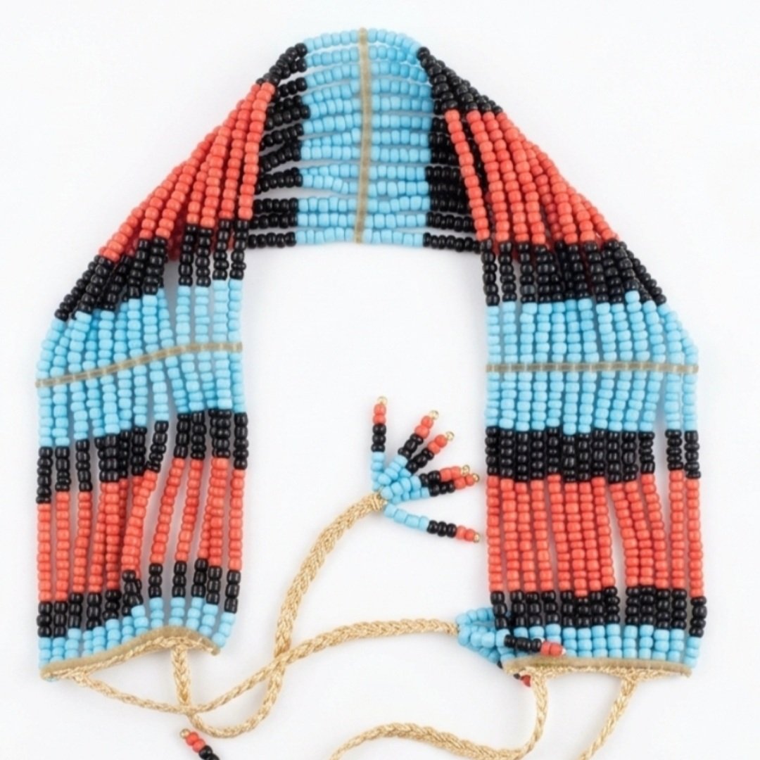 Beaded necklace with a pattern resembling the Argentine flag colors and design, featuring light blue, black, red, and beige beads, with beige string ties.