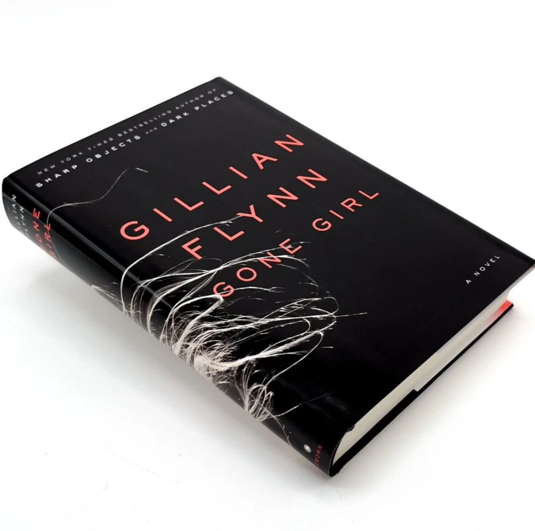 Black hardcover book titled "Gillian Flynn Gone Girl" with red and white text, featuring a dark and mysterious design.