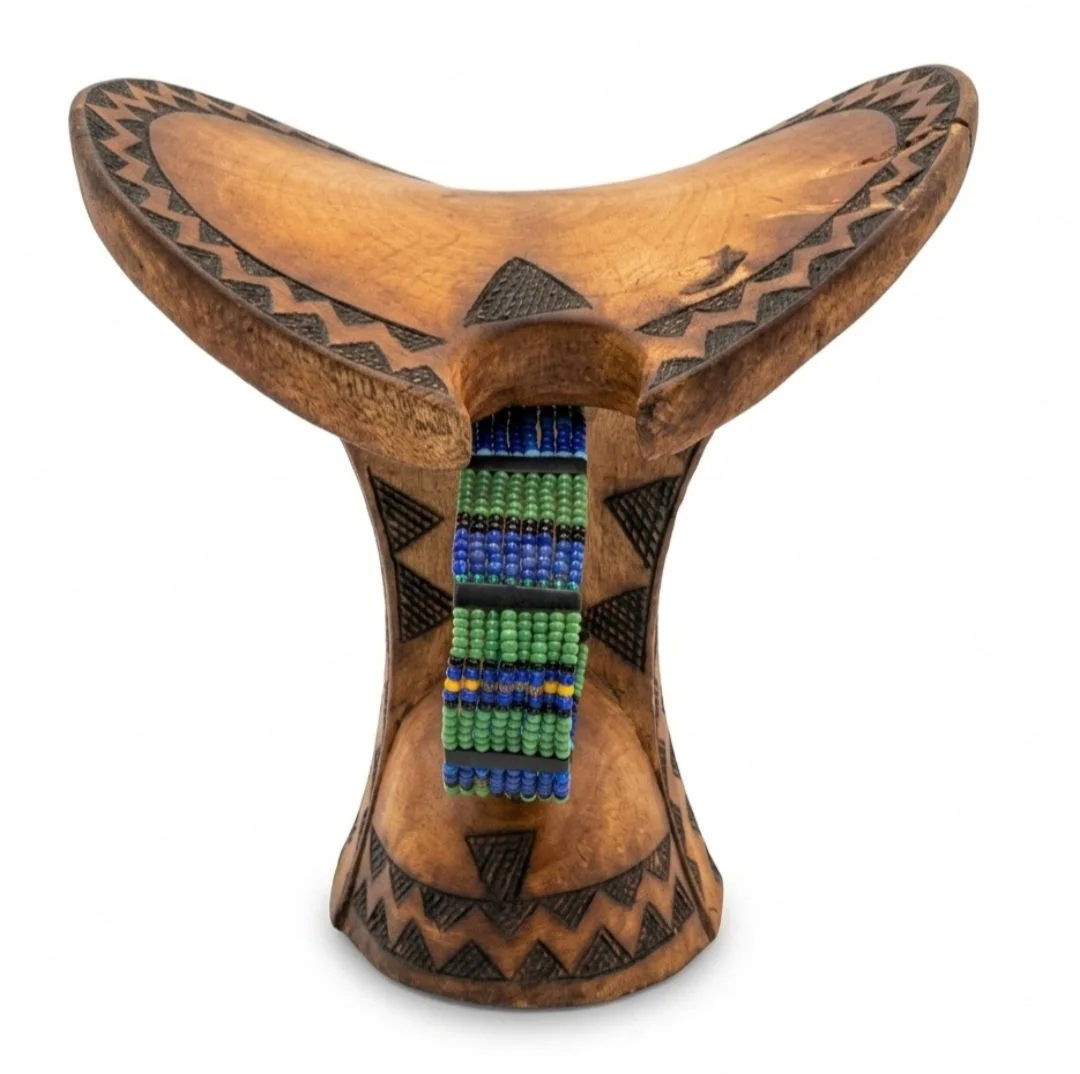 Wooden ancestor of a stool with black tribal designs and a seat decorated with beads in green and blue.