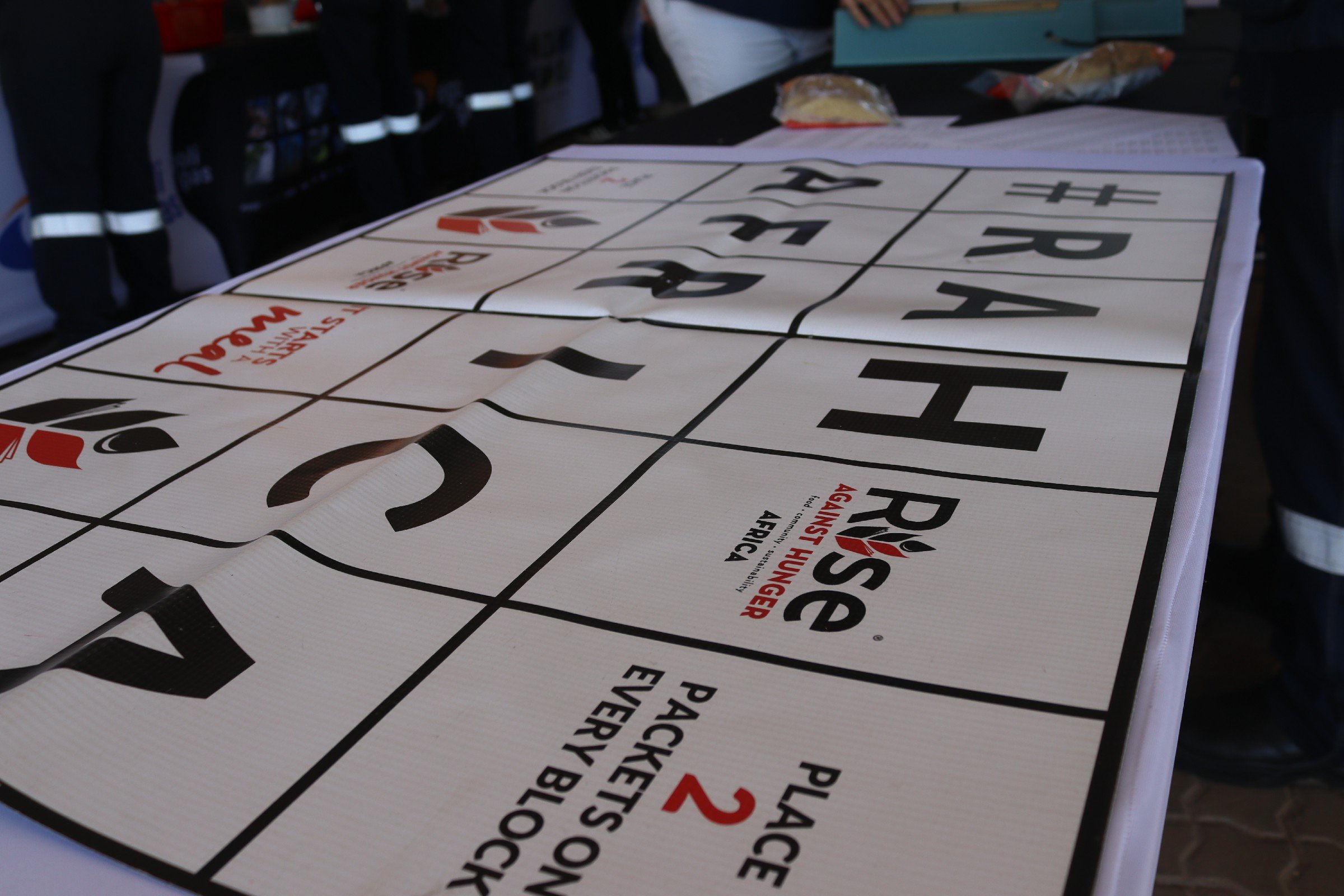 Table with a sign about race safety, featuring a grid with numbers and instructions, and food items in the background.