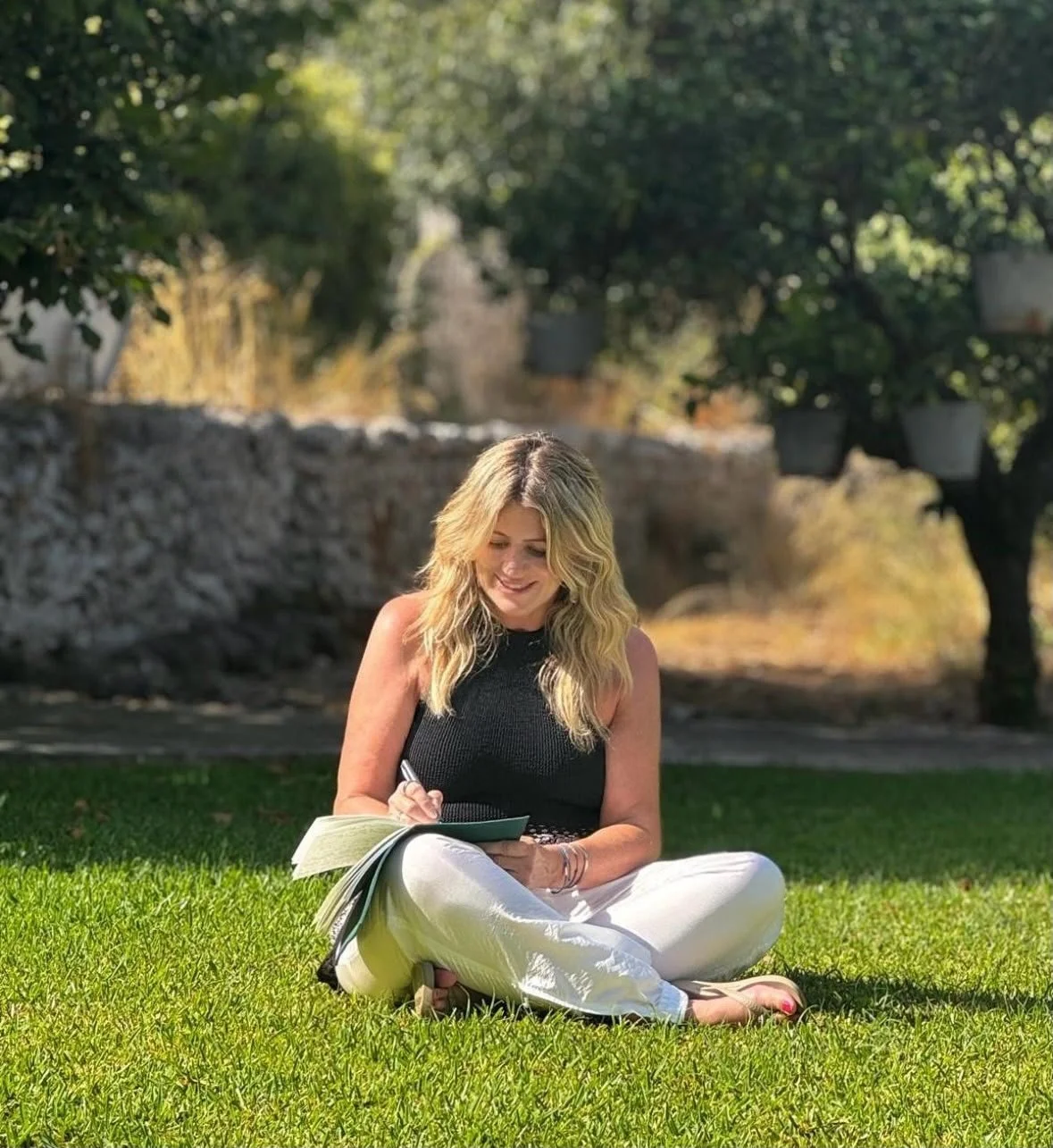 Jenny Ella writing in a notebook outdoors