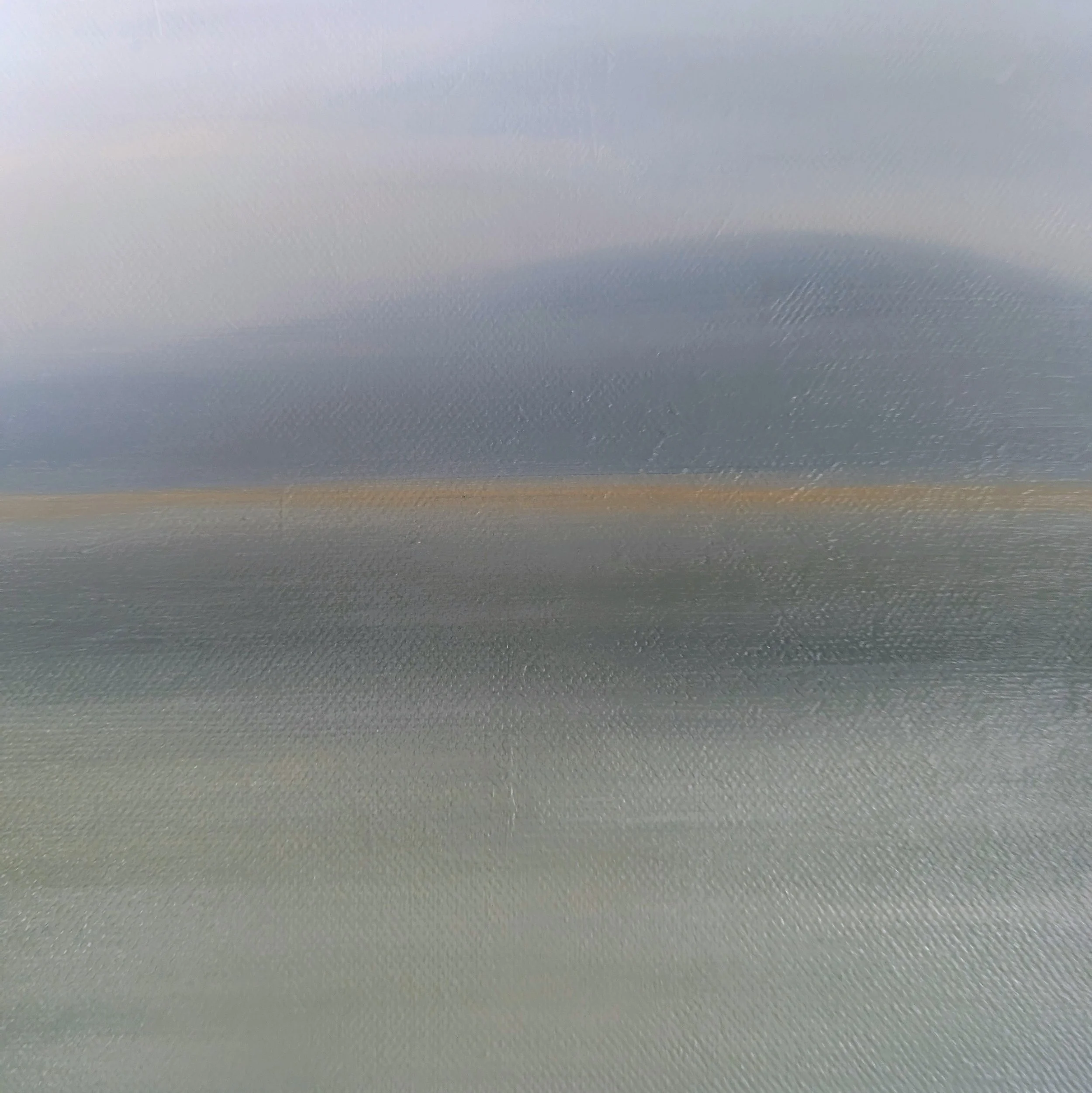A smooth, metallic surface with a slight gradient of light reflecting off it.